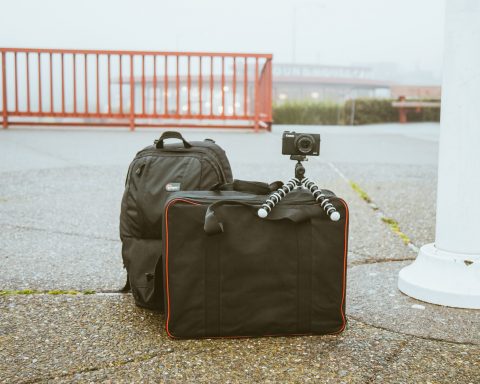 abandoned backpack, suitcase, and camera near bridge