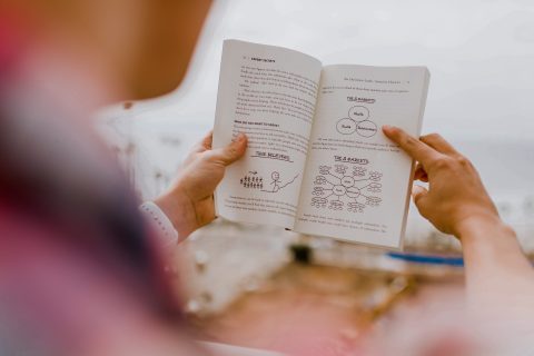 over-shoulder shot of man reading book on serving